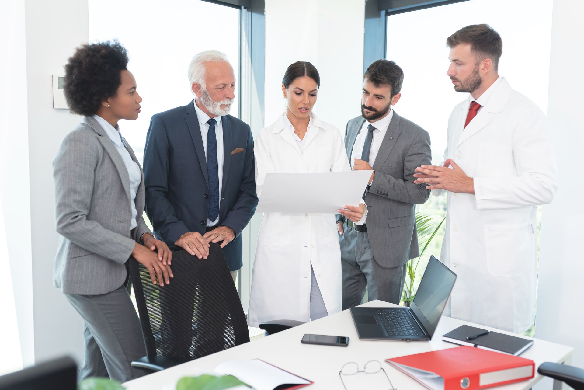 Business people with medical workers analyzing document at office
